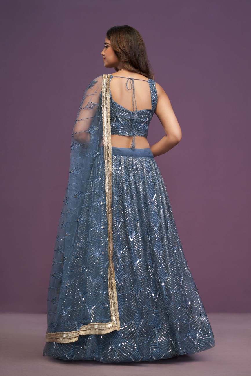Back view of model wearing slate blue sequin embellished lehenga choli with tie-up back blouse and sheer dupatta