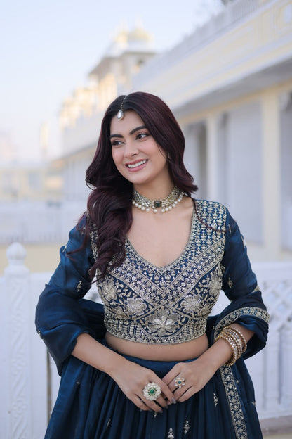 Mid-shot front view of model in a teal blue blouse with heavy thread and sequin embroidery and matching dupatta