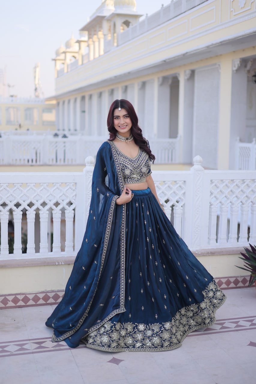 Side-angle full-length shot showcasing the flare and border embroidery of a teal blue lehenga with side-draped dupatta