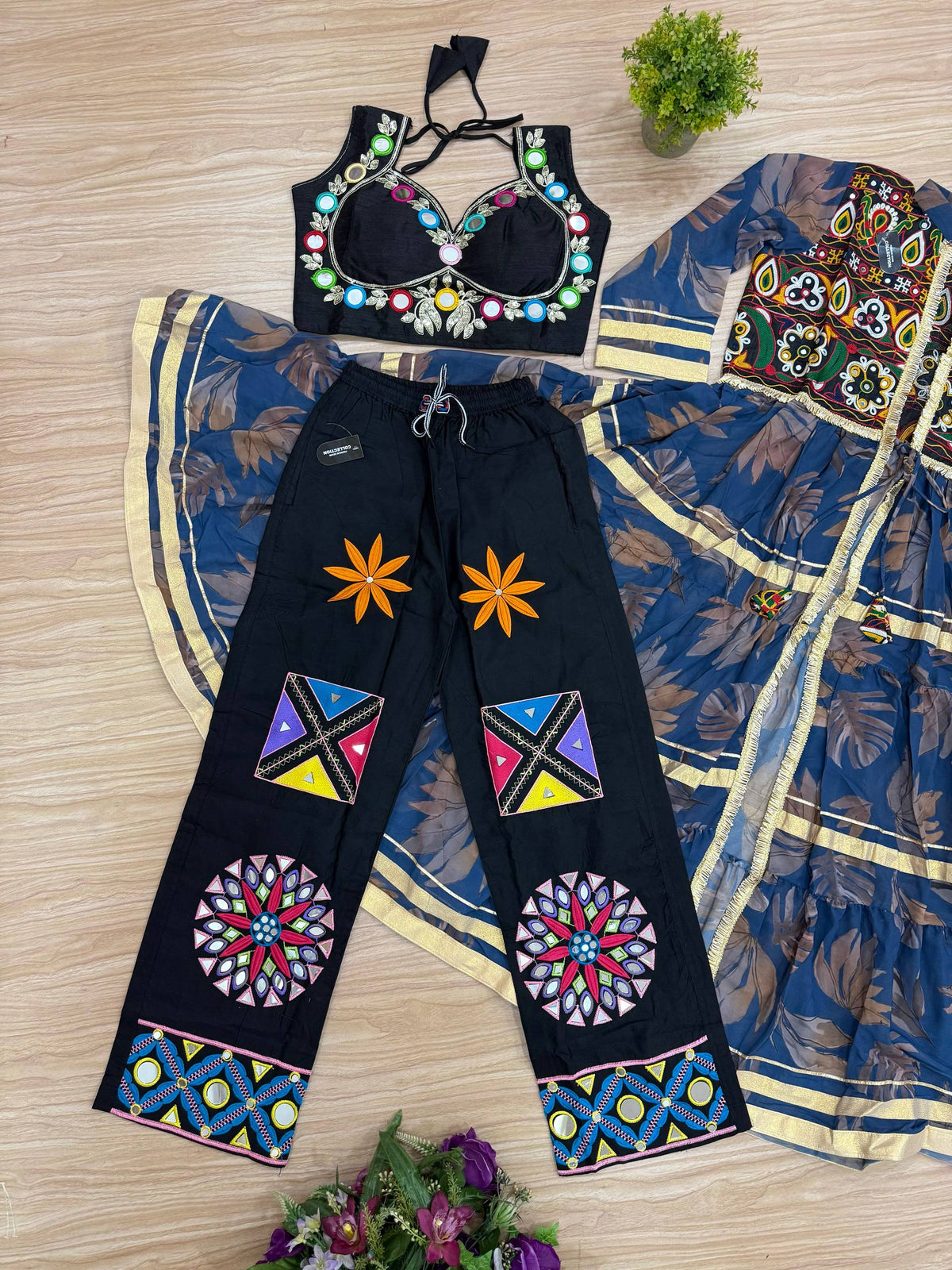 Flat lay view of the full 3-piece Indo-Western set including blue tiered jacket shrug, halter crop top, and patchwork palazzo pants.