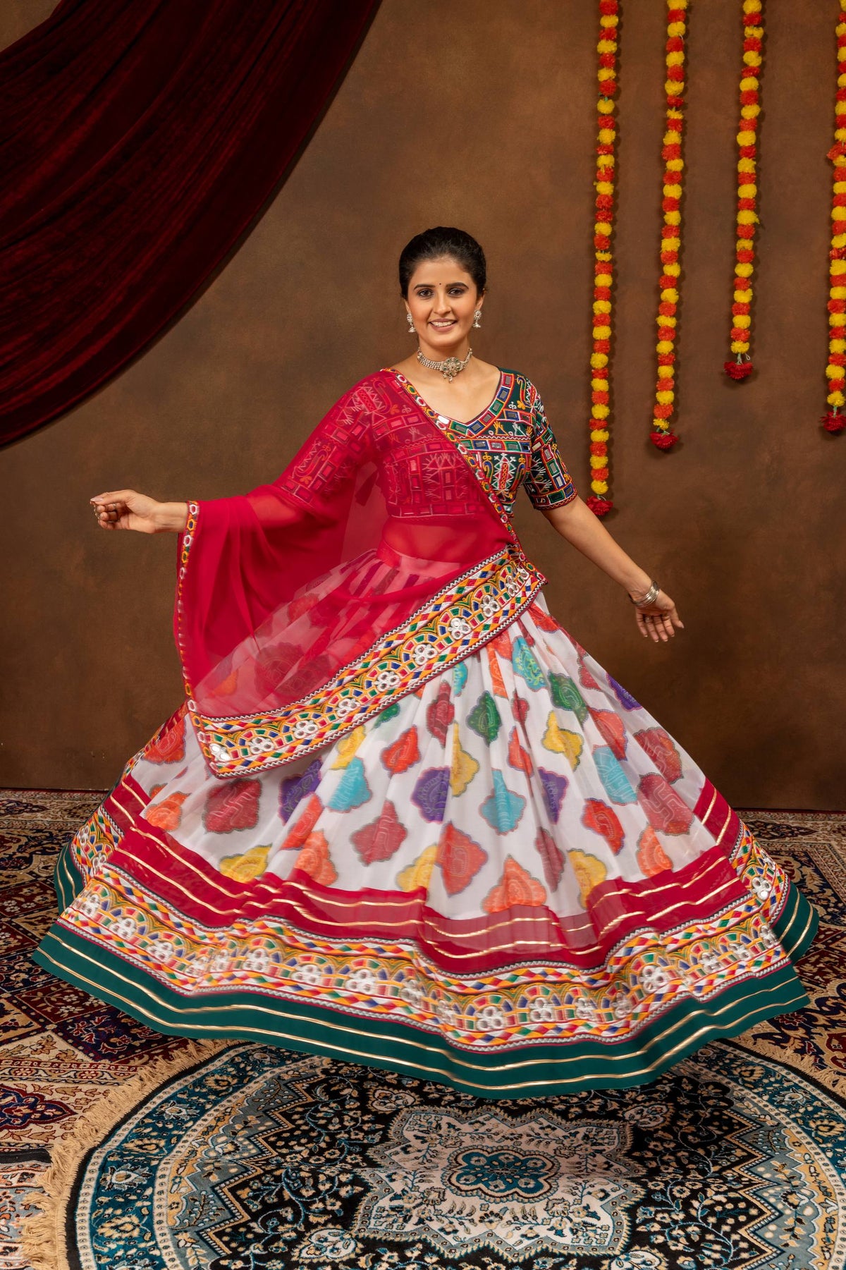 Full flared view of model posing in white multicolor printed lehenga skirt with embroidered border and pink dupatta