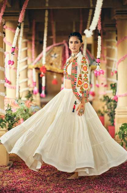 Full-length side view highlighting the wide gathered flare of a tiered white lehenga skirt and patterned white jacket