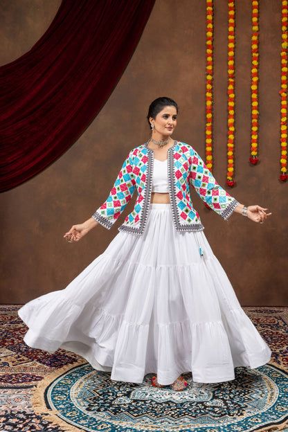 Model in open-arms pose wearing white tiered lehenga skirt and geometric mirror embroidered jacket