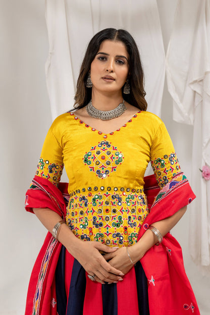 Close-up front view of yellow choli blouse featuring colorful mirror work embroidery and cowrie shell tassel fringe