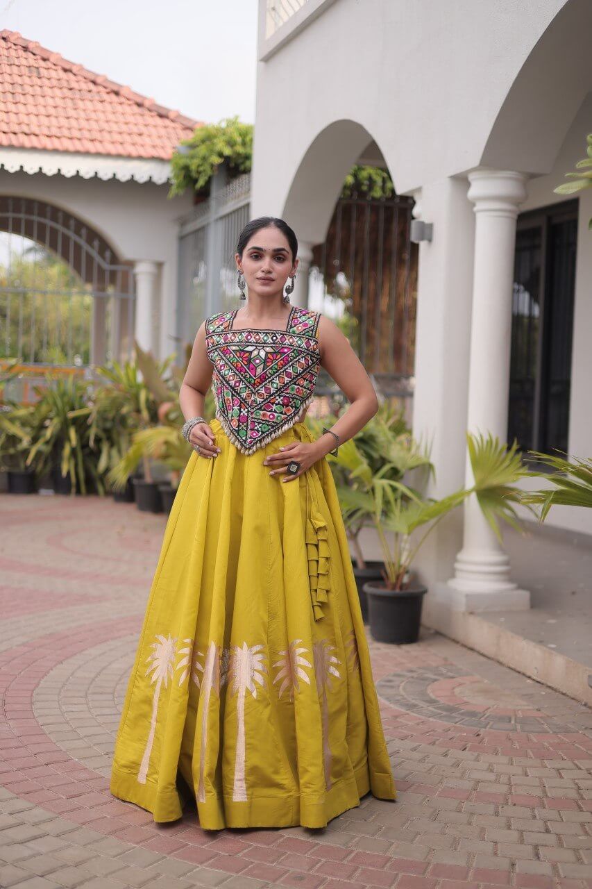 Yellow lehenga choli with multicolored embroidered blouse and floral skirt detailing