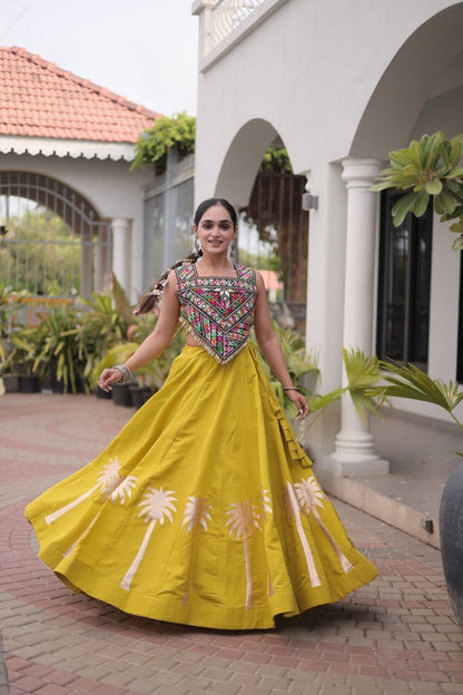 Front view of a yellow lehenga with a multicolored embroidered blouse and floral skirt detailing