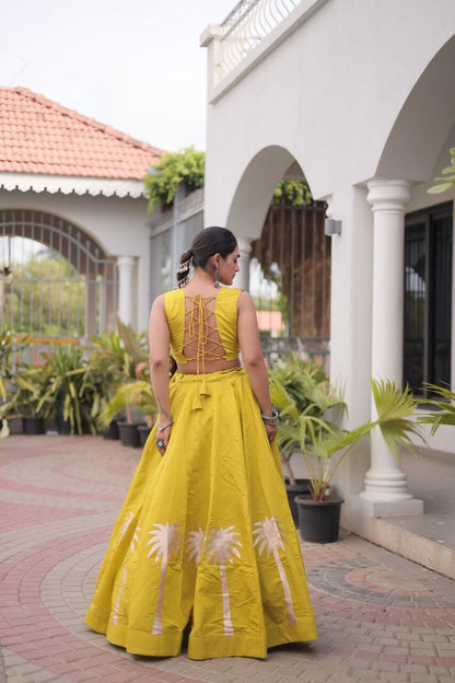 Yellow lehenga choli showing the lace-up back of the blouse and floral skirt detailing