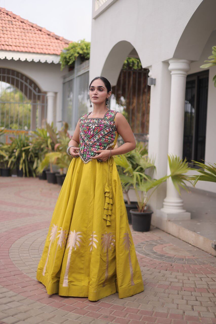 Yellow lehenga choli with multicolored patterned blouse and floral skirt detailing